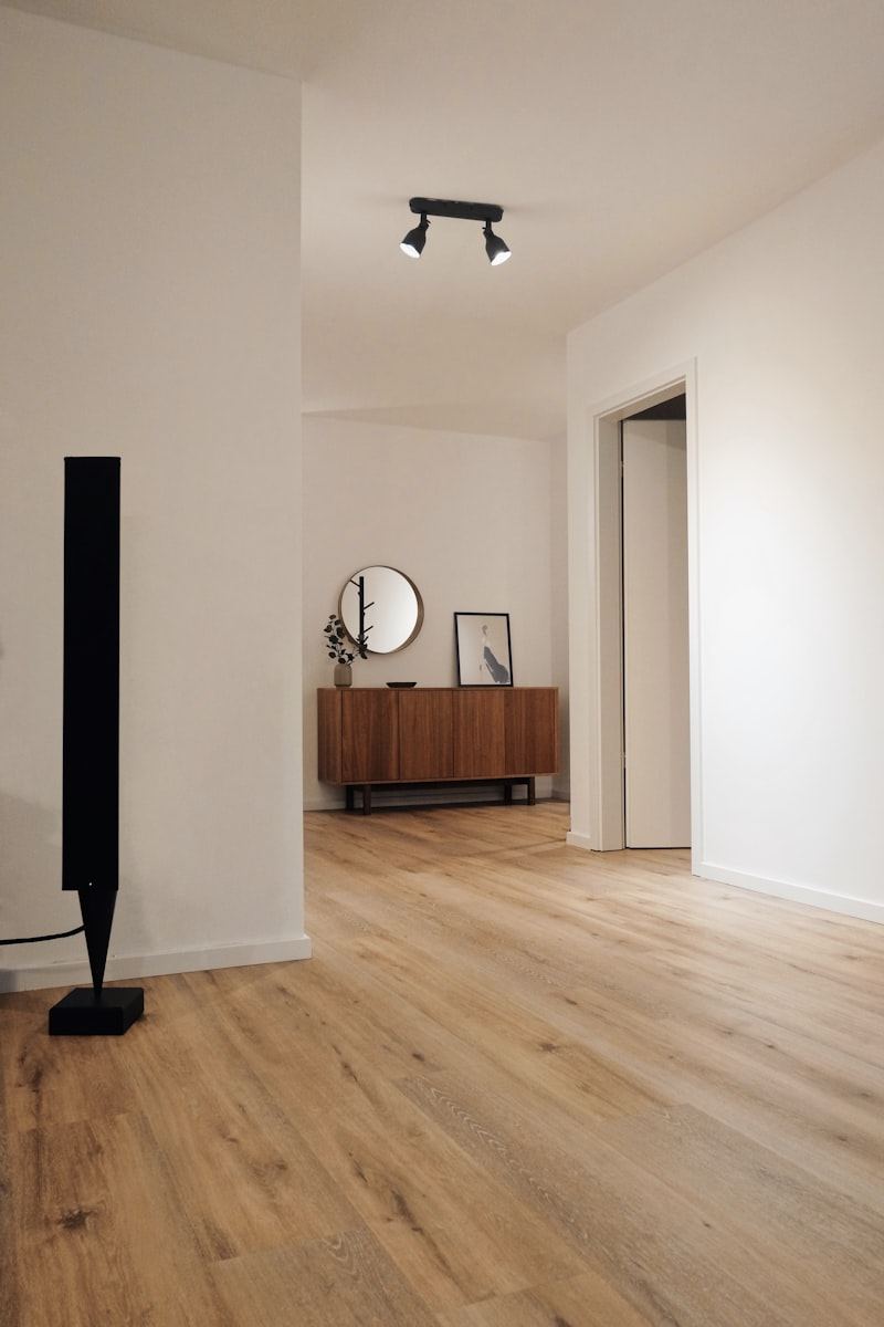 Freshly renovated hallway with twin ceiling spotlights, white walls and oak-effect flooring